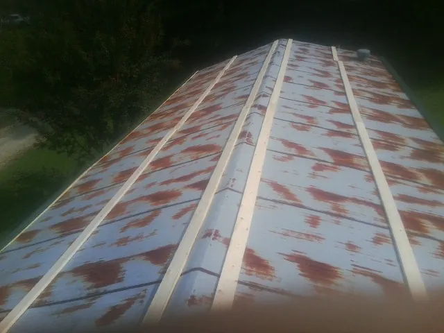 Rusted metal roof panels with new wood purlins before replacement — Storm Damage Roof Repair in Richlands by Roofing Brothers