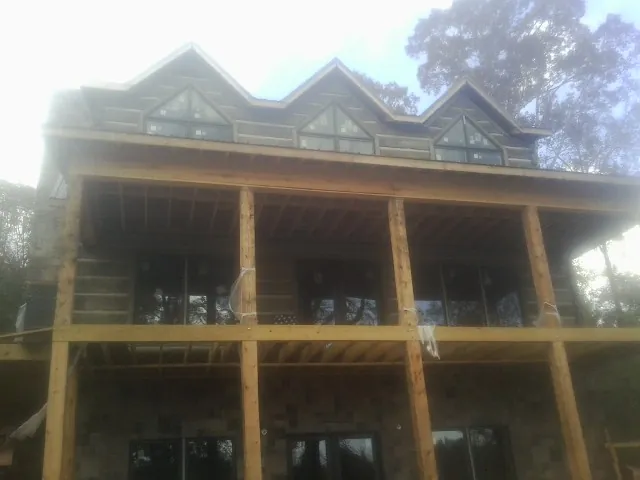 Dormers and porch framing on a large log home under construction — Roof Coating work by our crew in Richlands